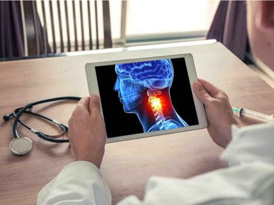 ENT surgeon reviewing head and neck anatomy imaging on a tablet