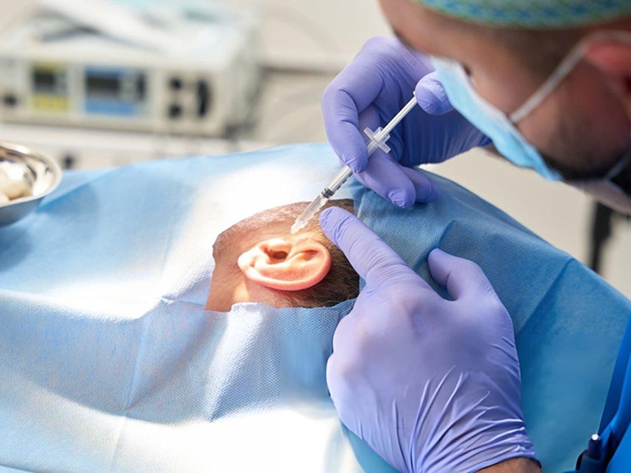 Microscopic ear surgery being performed in an operating theatre